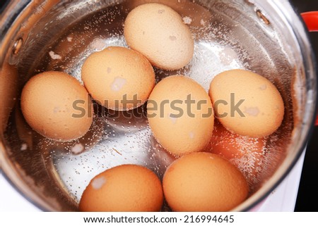 Eggs in boiling water in pan on electric hob