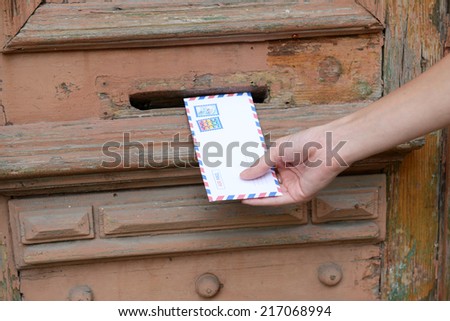 Letter in hand near postbox