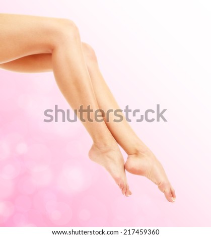 Beautiful woman legs on bright pink background