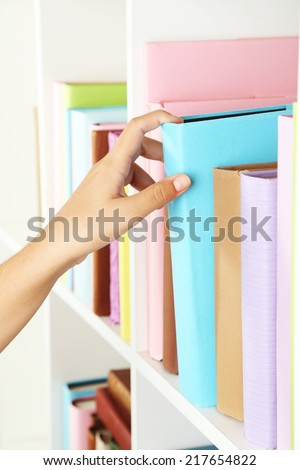 Hand picking book in library