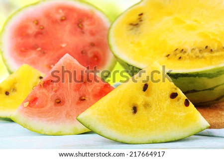 Slices of red and yellow watermelons  on wooden background closeup