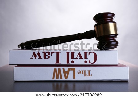 Books of Law and hammer on table on grey background