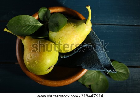 Ripe tasty pears in wooden bowl on table