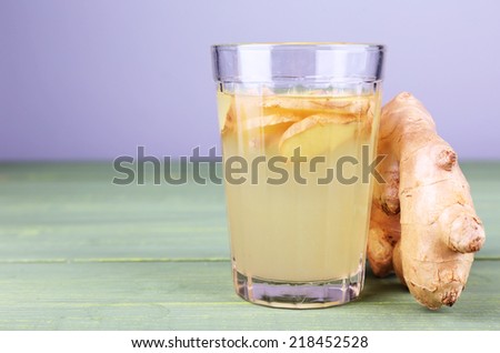 Ginger drink on wooden table on light background