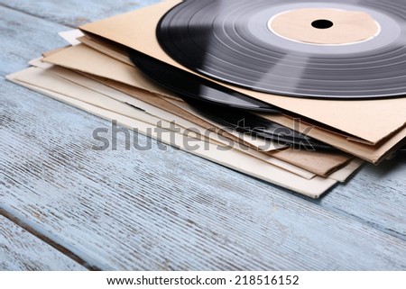 Vinyl records records and paper covers on wooden background