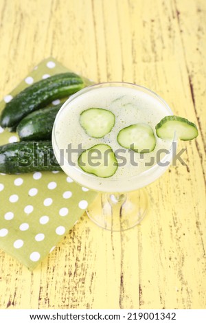 Cucumber cocktail on polka dot napkin on wooden background