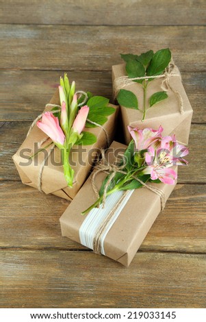 Natural style handcrafted gift boxes with fresh plants and rustic twine, on wooden