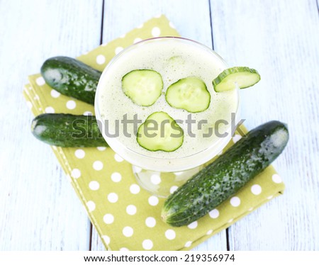Cucumber cocktail on polka dot napkin on wooden background