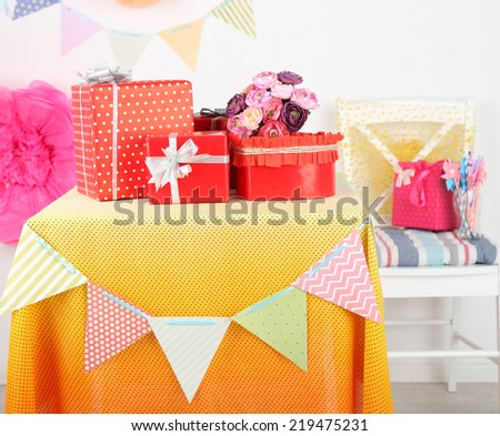 Wedding or birthday gifts on decorated table, on bright background
