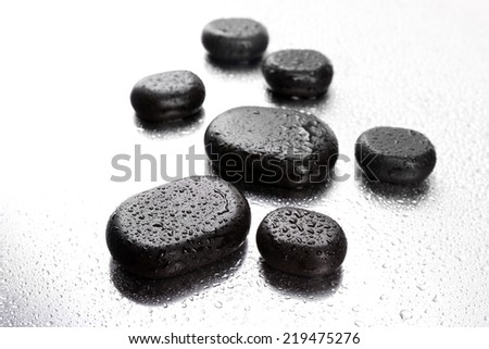 Spa stones with drops on light background