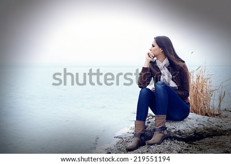 Young serious woman near river