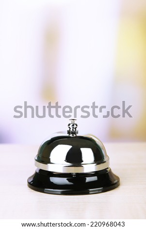 Reception bell on desk, on bright background