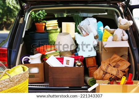 Moving boxes and suitcases in trunk of car, outdoors