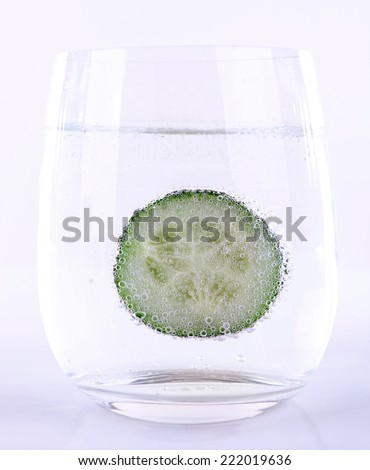 Cucumber in glass of water isolated on white