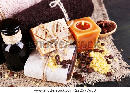Organic soap with coffee beans, sea salt on wicker mat, on  table, on dark background, Coffee spa concept