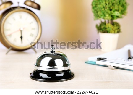 Reception bell on hotel reception desk, on bright background