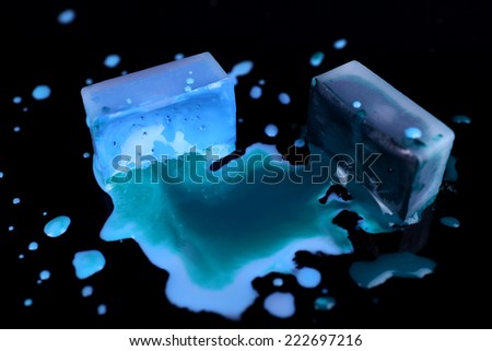 Watercolor paint cubes and spilled paint isolated on black