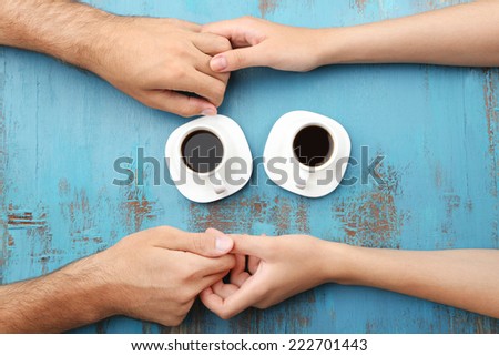 Loving couple with hot drinks on table