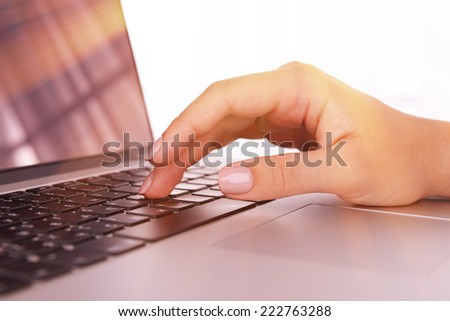 Female hands on laptop, close-up