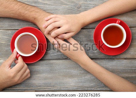 Loving couple with hot drinks on table