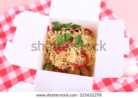 Chinese noodles in takeaway boxes on fabric background