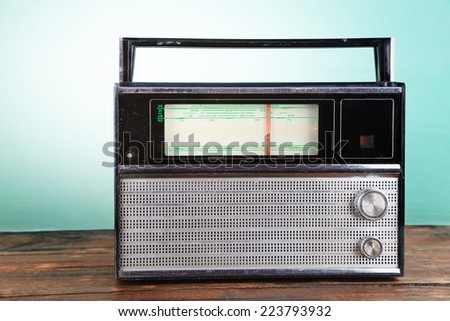 Old radio set on wooden table on blue background