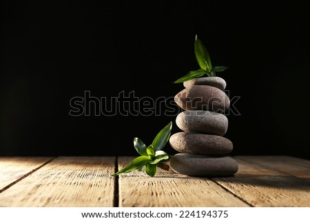 Spa stones and bamboo on wooden table on dark background