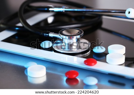 Stethoscope, pills, PC tablet on light background. medicine concept