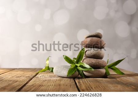 Spa stones and bamboo on wooden table on light background