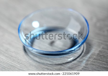 Contact lens with water drops on bright background