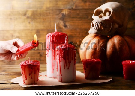 Process of lighting candles for Halloween party. Female hand holding candle, close-up