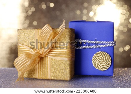 Blue and golden gift boxes on table on shiny background