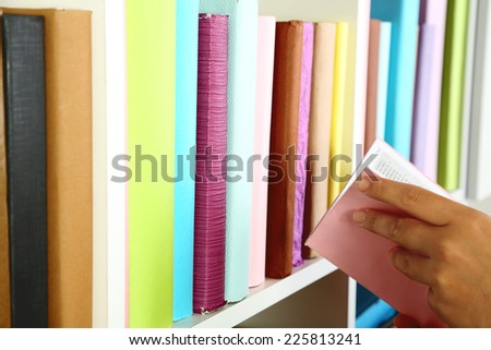 Hand picking book in library