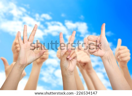Young people\'s hands on sky background