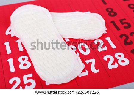 Sanitary pads on red calendar background