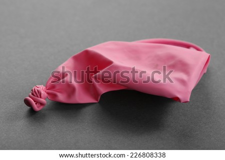 Popped pink balloon on paper background