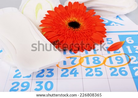 Sanitary pads, orange Gerber on blue calendar background