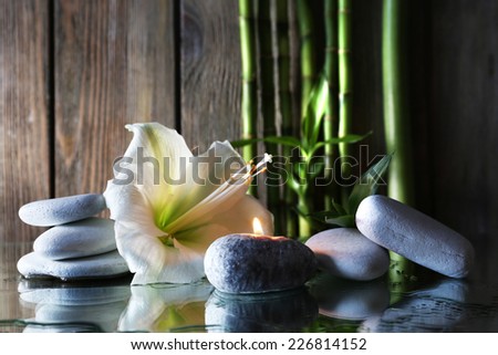 Spa set on mirror surface on wooden wall background
