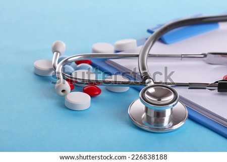 Stethoscope pills and bottles on color background medicine concept Stethoscope pills and bottles on color background medicine concept