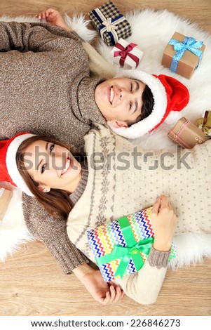 Happy couple with Christmas gifts relaxing at home