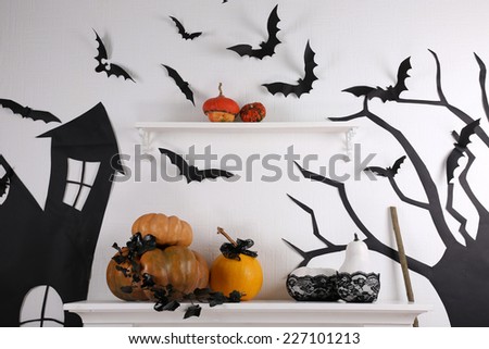 Halloween composition on fireplace in room