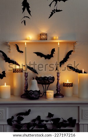 Halloween composition on fireplace on white wall background
