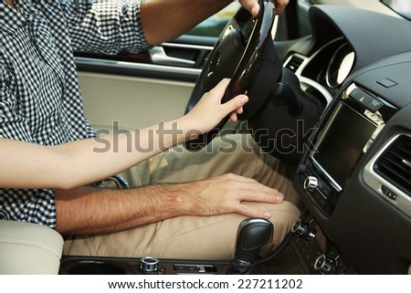 Loving couple holding hands in car close-up