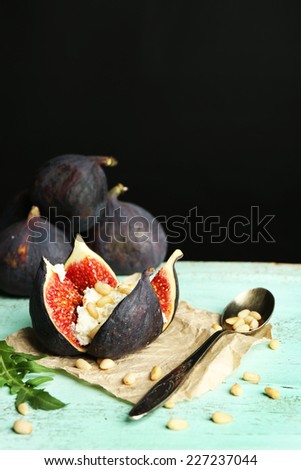 Ripe sweet fig with cottage cheese on wooden table, on dark background