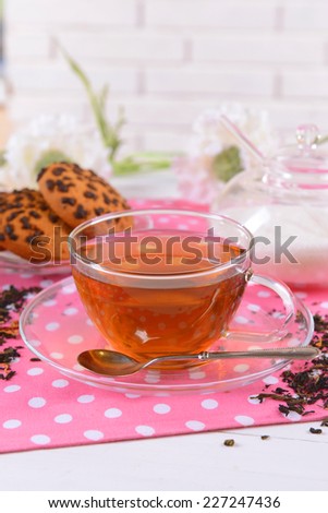 Cup of tea on table on brick wall background