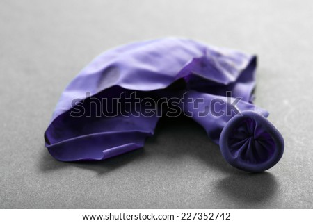 Popped violet balloon on paper background