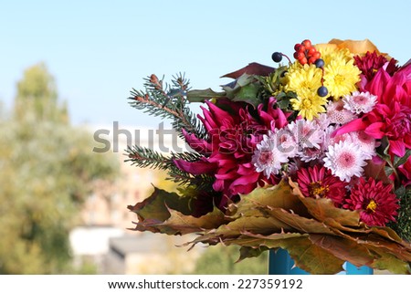 Flower bouquet in blue vase on table on natural background