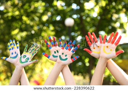Smiling colorful hands on natural background