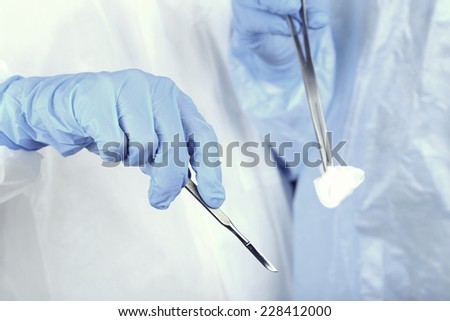 Surgeon\'s hands holding different instruments close up