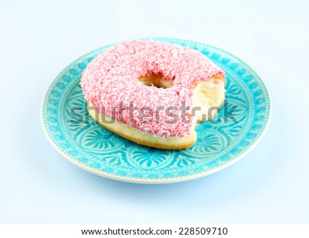 Bitten delicious donut on plate isolated on white